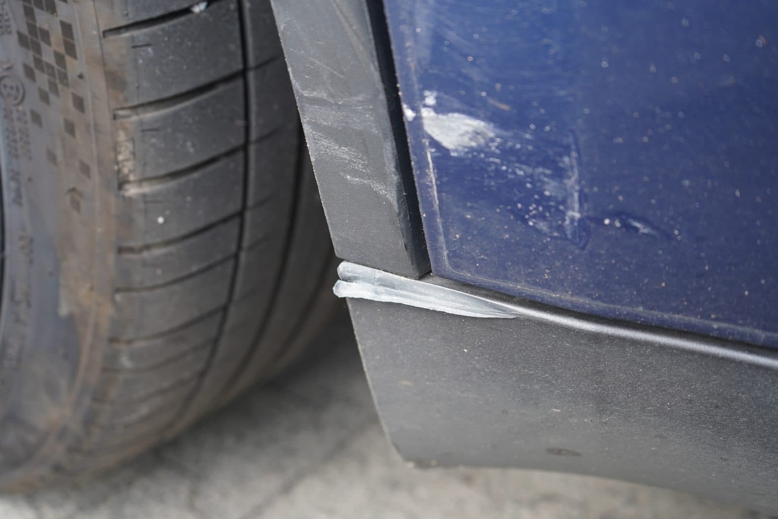 Beschädigte Seitenschwellerverkleidung und Radlaufverbreiterung hinten rechts am Tesla Model Y