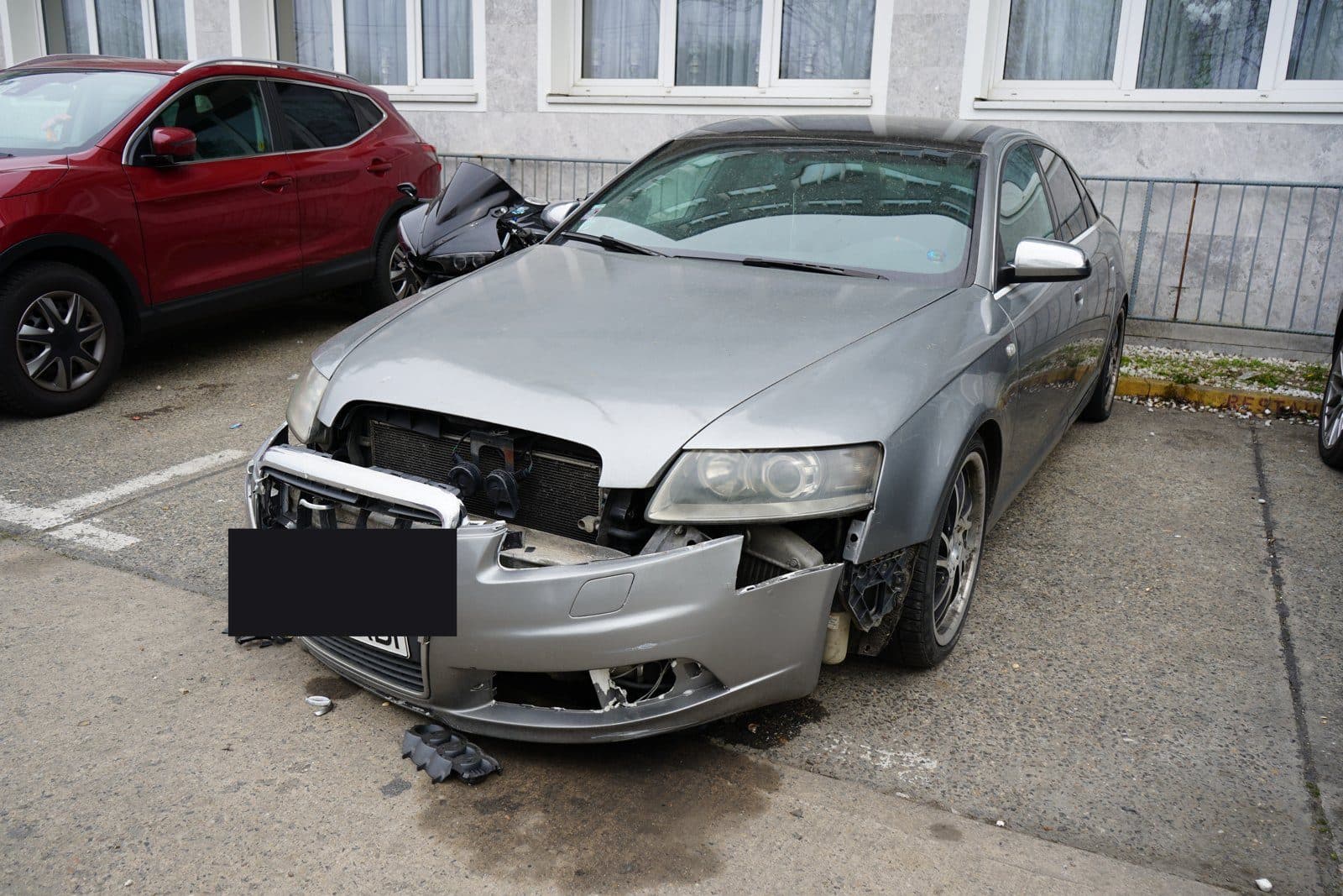 Silberner Audi A6 mit zerstörter Front, Kennzeichen abgedeckt