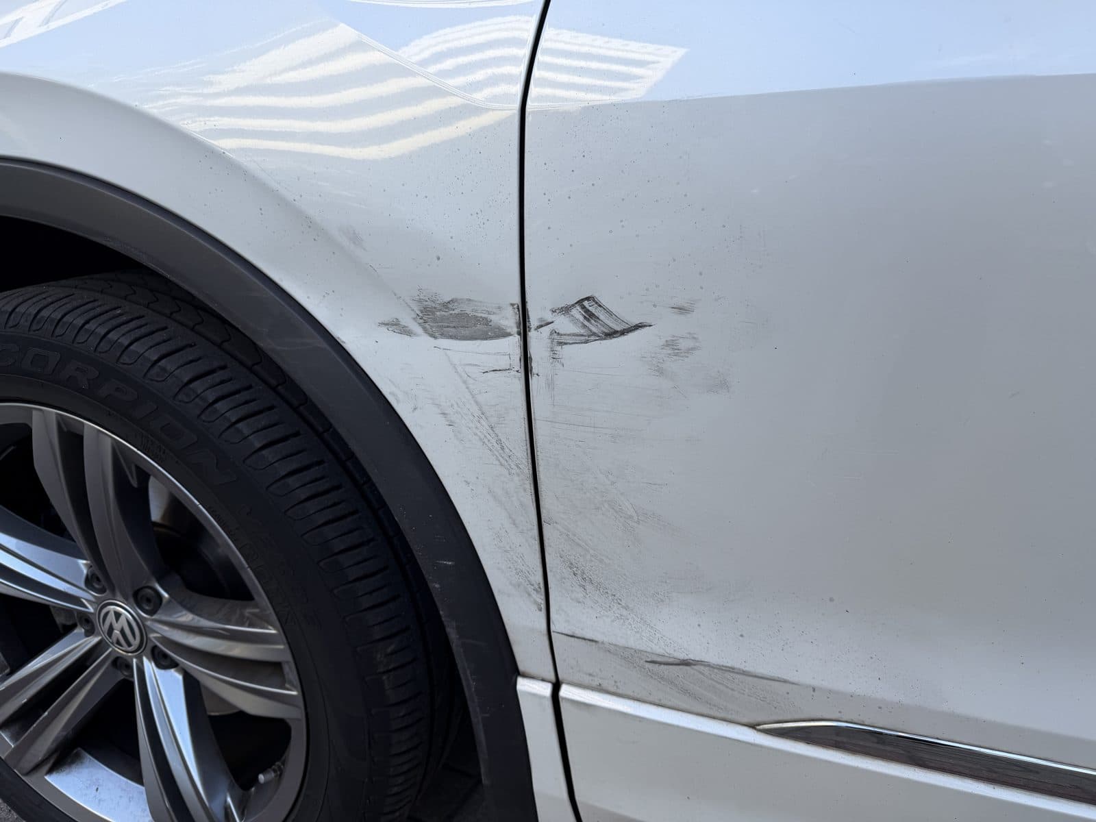 Streifschaden über Kotflügel und Fahrertür des VW Tiguan