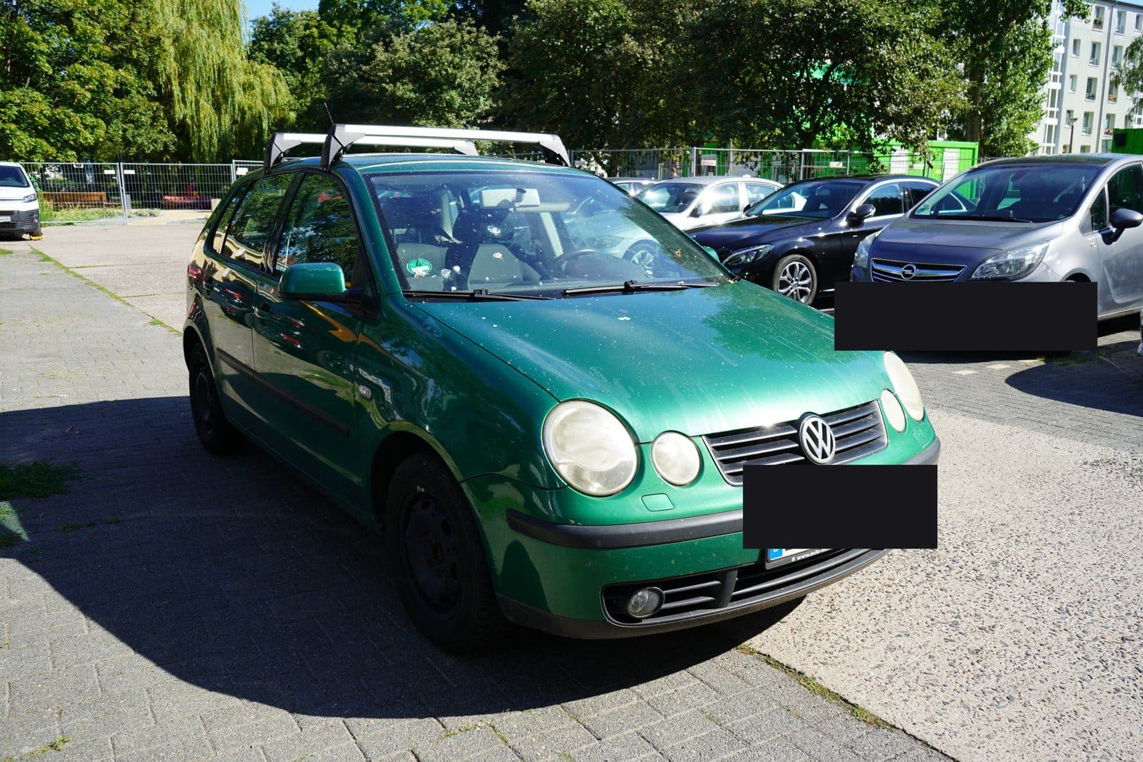 Grüner VW Polo auf einem Parkplatz in Karow, Kennzeichen abgedeckt