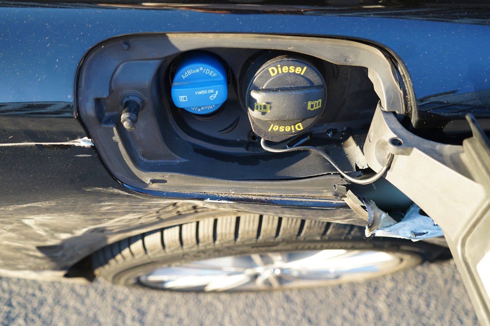 Beschädigte Tankklappe mit Diesel- und AdBlue-Verschluss am Audi S6 Avant