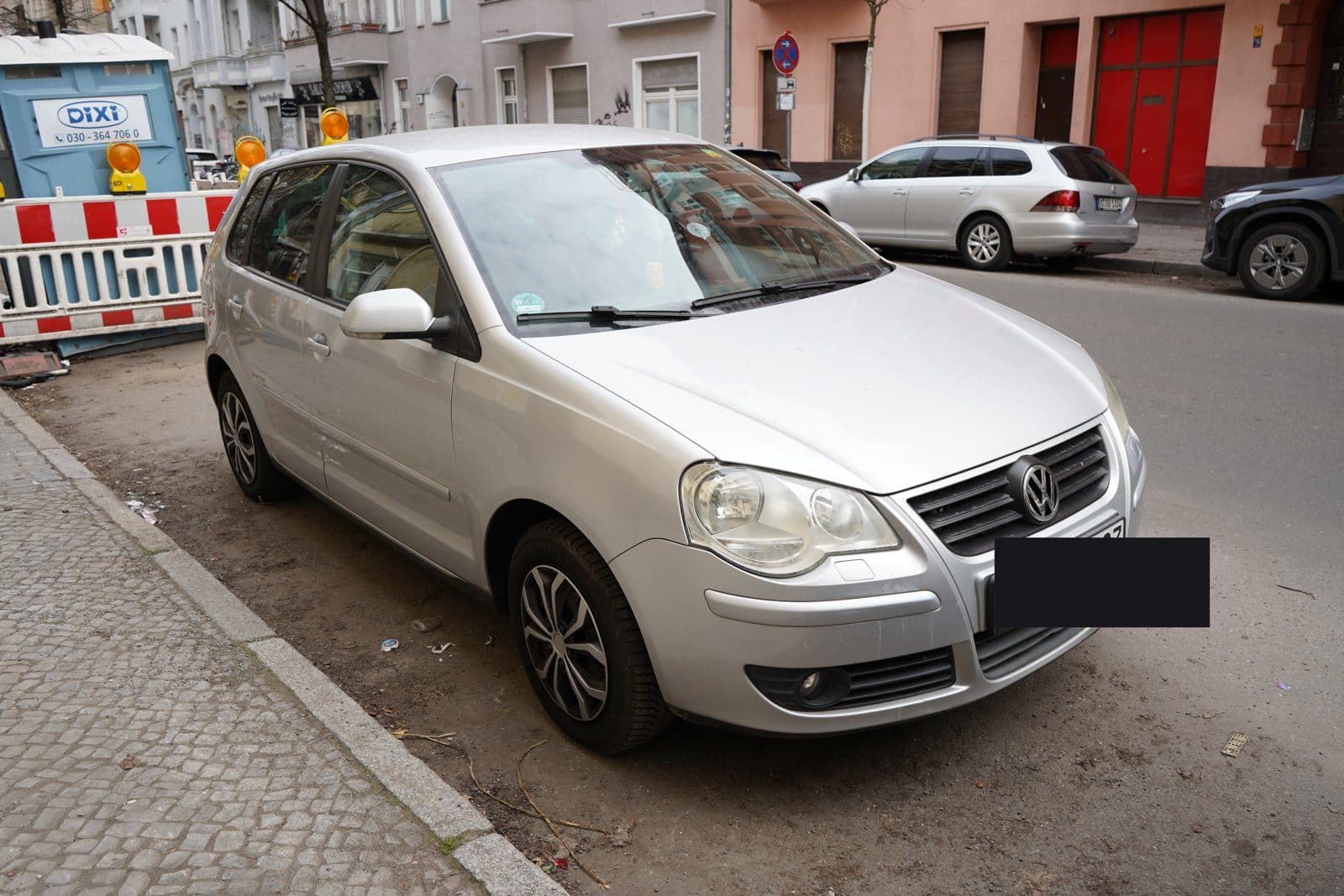 Silberner VW Polo in einer Wohnstraße, Kennzeichen abgedeckt