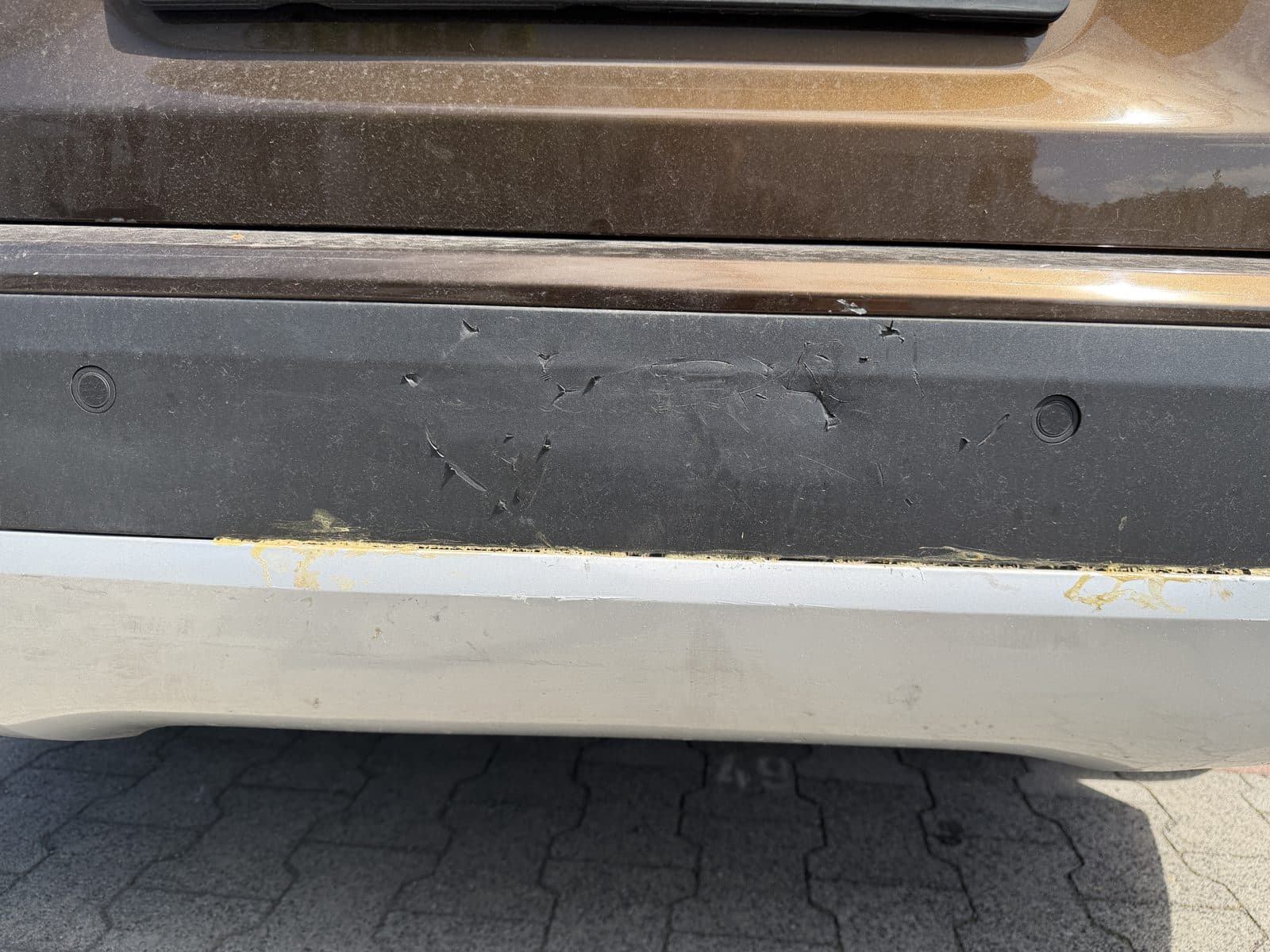 Unterer Heckstoßfänger mit älterem, abblätterndem Schaden