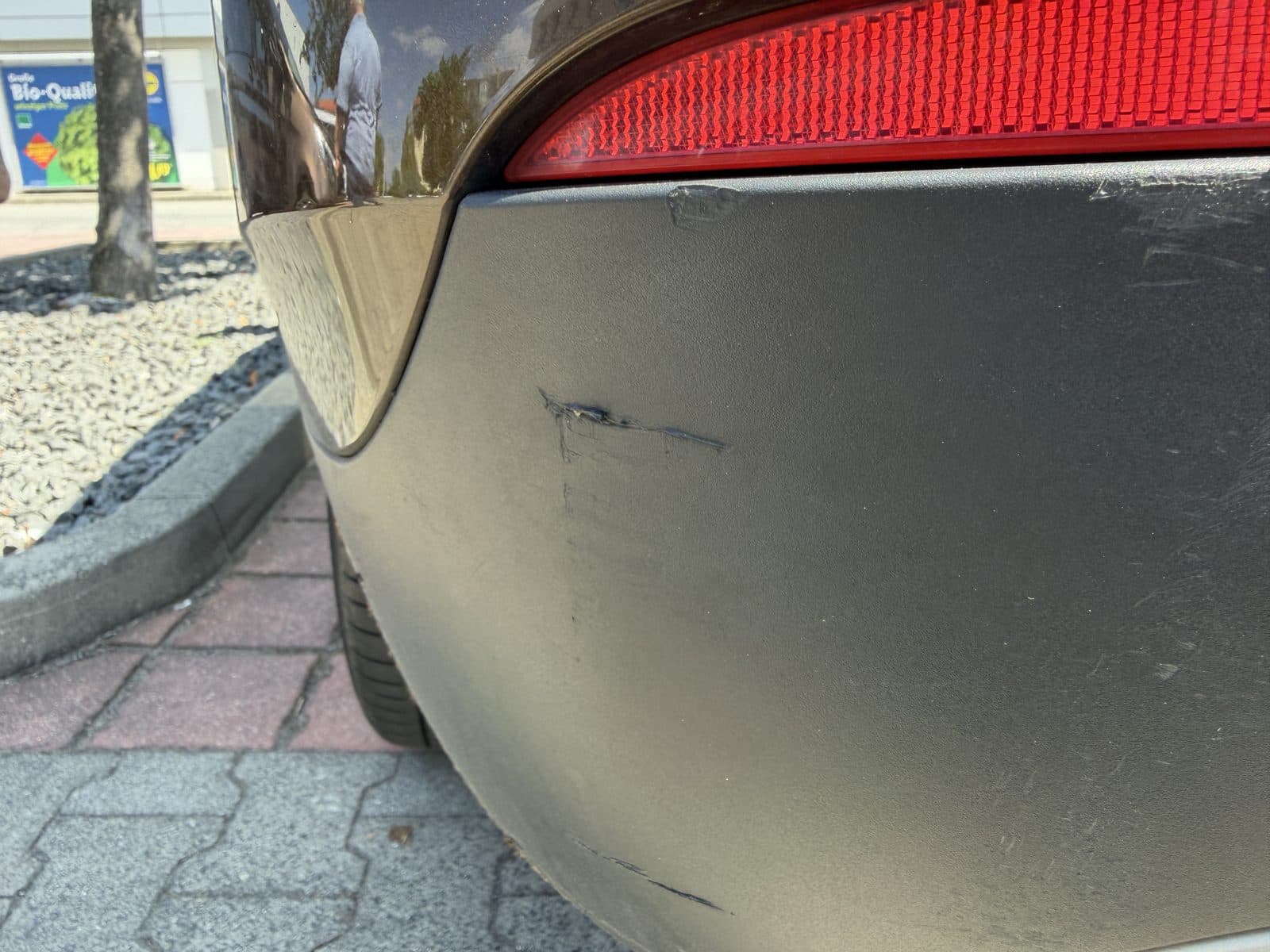 Frischer Knick am oberen Heckstoßfänger neben dem Reflektor